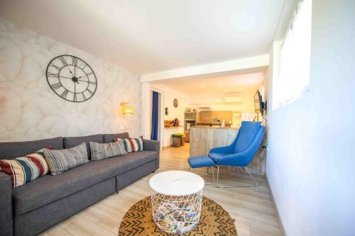 a living room with a couch and a clock on the wall at Git chez BOUBET 1 in Arnos