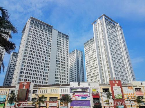 three tall white buildings in a city at New Furnished Studio Apartment at M-Town Residence By Travelio in Pumpangsineng
