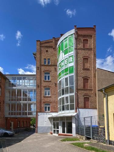 a tall brick building with a green window at Sacher s Quartiere Mühlhausen in Mühlhausen