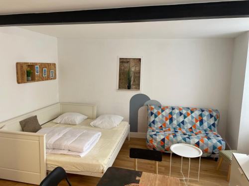 une petite chambre avec un lit et une chaise dans l'établissement Studio centre ville, à La Rochelle