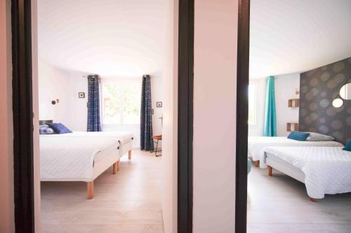 a bedroom with two beds and a mirror at Git chez BOUBET 1 in Arnos