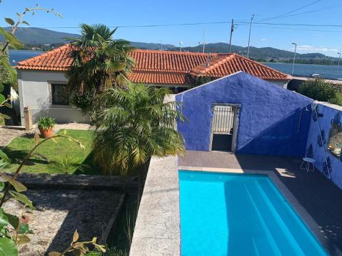 a blue house with a swimming pool in front of it at Villa Elia in Seixas