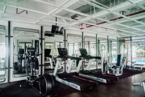 a gym with treadmills and elliptical machines at Best Deal and Homey 1BR Apartment Carstensz Residence By Travelio in Kampung Sawah