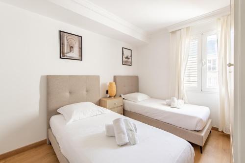 une chambre avec deux lits et une fenêtre dans l'établissement New York-Superbe appartement vue Tour Eiffel pont de l'Alma, à Paris