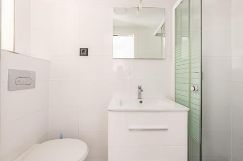 une salle de bain blanche avec des toilettes et un lavabo dans l'établissement New York-Superbe appartement vue Tour Eiffel pont de l'Alma, à Paris