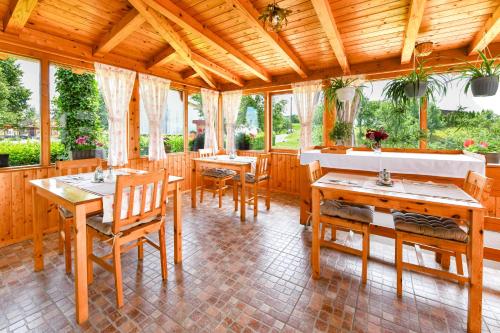 een eetkamer met houten tafels en stoelen bij House Marija B&B in Seliste Dreznicko
