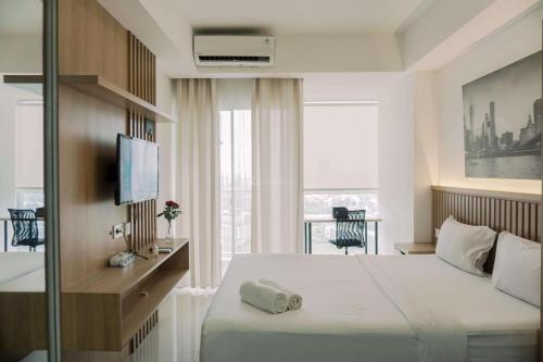 当格浪Good and Homey Studio at Pacific Garden Alam Sutera Apartment By Travelio的一间有床和窗户的酒店房间