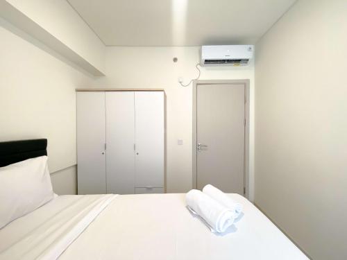 芝卡朗Comfortable and Spacious 3BR Meikarta Apartment By Travelio的卧室配有白色的床和衣柜。