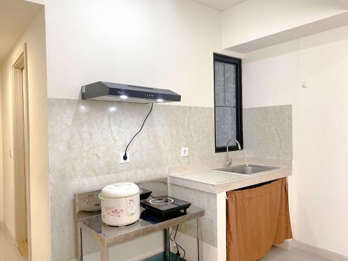 芝卡朗Comfortable and Spacious 3BR Meikarta Apartment By Travelio的带水槽和炉灶的厨房