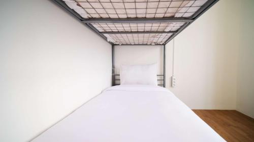 a large white room with a bed in it at Wonderful 2BR Combine at Bale Hinggil Apartment By Travelio in Medokanayu