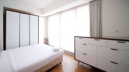Postel nebo postele na pokoji v ubytování Homey 3BR with Private Lift at Grand Sungkono Lagoon Apartment By Travelio