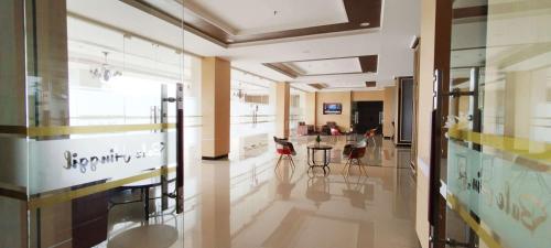 a large room with a lobby with a table and chairs at Best Choice and Cozy Living 2BR at Bale Hinggil Apartment By Travelio in Medokanayu