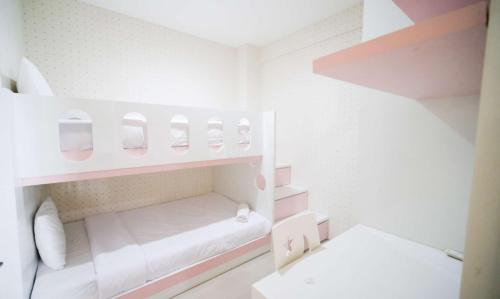 a small white room with pink and white shelves at Best Choice and Cozy Living 2BR at Bale Hinggil Apartment By Travelio in Medokanayu