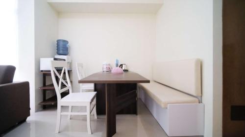 a small room with a table and a refrigerator at Best Choice and Cozy Living 2BR at Bale Hinggil Apartment By Travelio in Medokanayu