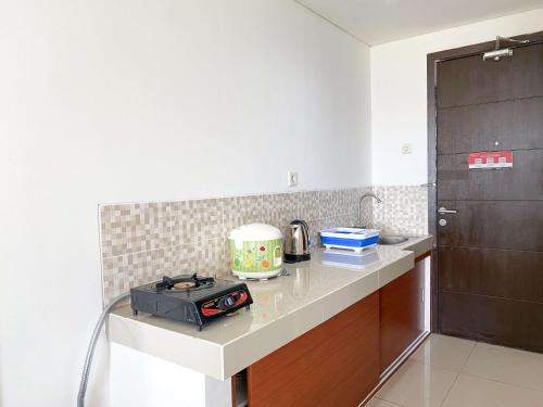 a kitchen with a counter with a toaster on it at Warm and Comfy Studio at Enviro Apartment By Travelio in Cikarang