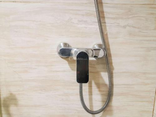 a shower head with a hose attached to a door at Brand New and Good Simply 1BR at Uttara The Icon Apartment By Travelio in Kejayan