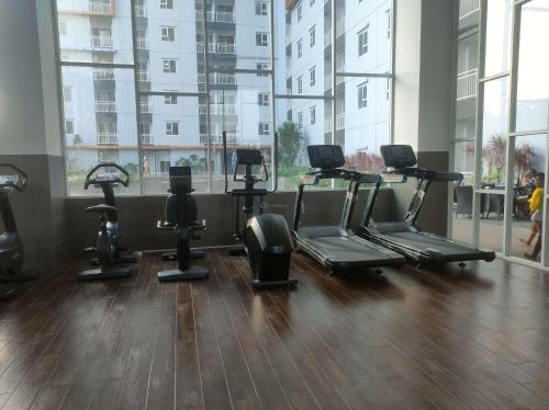 a gym with a row of exercise bikes in a room at New and Homey 2BR Apartment at Suncity Residence By Travelio in Sidoarjo