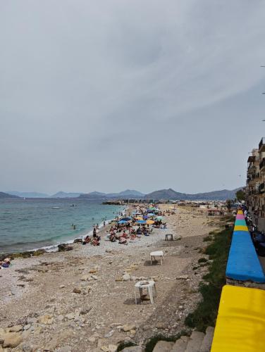 a beach with a bunch of people and the ocean at Il Balcone sul mare - free parking & relax in Palermo