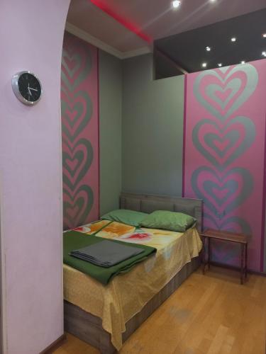 a bed in a room with a pink wall at Tatapartment in Tbilisi City