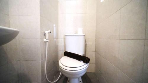 a bathroom with a toilet with a black towel on it at Tidy and Cozy Stay Studio Apartment at Suncity Residence By Travelio in Sidoarjo