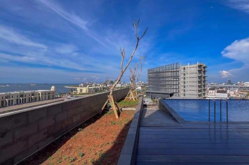 a tree sitting on top of a building next to the water at Good Choice Studio at Delft Ciputra Makassar Apartment By Travelio in Sungguminasa