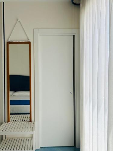 a bedroom with a mirror and a white door at B&B Casa di Emma in Porto Cesareo