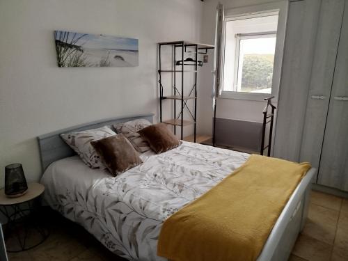 a bedroom with a bed and a window at Maison à 100 m de la plage à St Hilaire de Riez in Saint-Hilaire-de-Riez