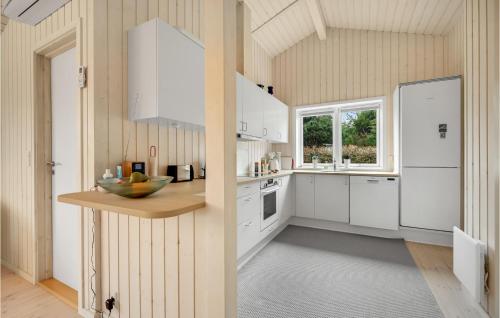a kitchen with white cabinets and a window at Nice Home In Beder With Kitchen in Beder