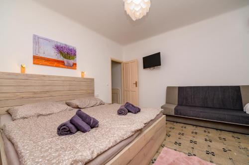 a bedroom with a bed with purple pillows on it at Holiday house Nerezine in Nerezine