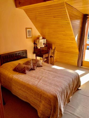 une chambre avec un grand lit dans une pièce dans l'établissement Villa du Lys Bagnères de Luchon, à Luchon