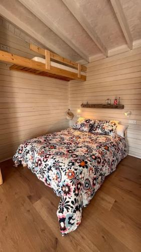 a bedroom with a bed with a floral comforter at La Casita in Cuartillos