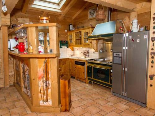 Il comprend une grande cuisine équipée d'un réfrigérateur et d'une cuisinière. dans l'établissement Chalet 8 pièces, 16 pers, proche village, parking, WiFi, animaux admis - FR-1-676-112, à Châtel