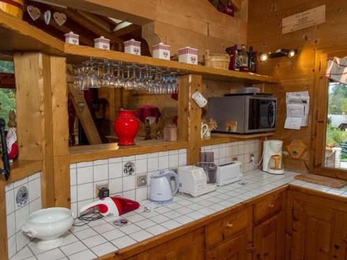 une cuisine avec des armoires en bois et un comptoir dans l'établissement Chalet 8 pièces, 16 pers, proche village, parking, WiFi, animaux admis - FR-1-676-112, à Châtel