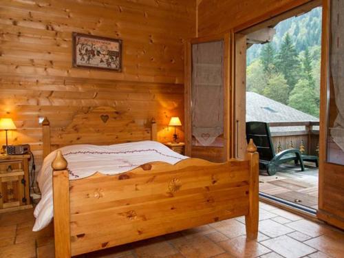 une chambre avec un lit dans une cabane en rondins dans l'établissement Chalet 8 pièces, 16 pers, proche village, parking, WiFi, animaux admis - FR-1-676-112, à Châtel