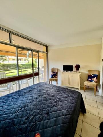 une chambre avec un lit bleu et un balcon dans l'établissement Nice with pool and beach, à Saint-Laurent-du-Var