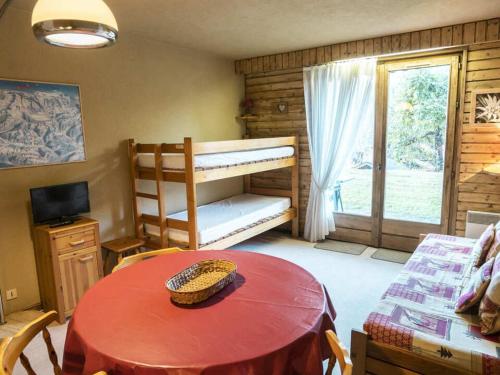Cette chambre comprend une table et des lits superposés. dans l'établissement Studio 3 pers. avec terrasse - 100m des remontées, parking, et navettes à proximité - FR-1-676-102, à Châtel