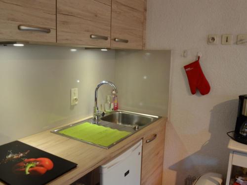 - une cuisine avec un évier et une serviette verte dans l'établissement Studio Mezzanine, Châtel - Proche Village et Remontées, 4 Pers., Parking, Balcon, Cuisine équipée - FR-1-676-161, à Châtel