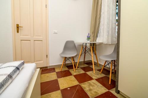 a room with two chairs and a checkerboard floor at Holiday house Nerezine in Nerezine