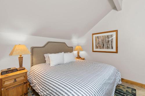 a bedroom with a bed with a striped bedspread and two lamps at 2 BR Condominium - Luxury Skiin and out (rare to find) in Telluride