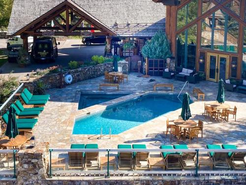 a pool with tables and chairs and a building at 2 BR Condominium - Luxury Skiin and out (rare to find) in Telluride