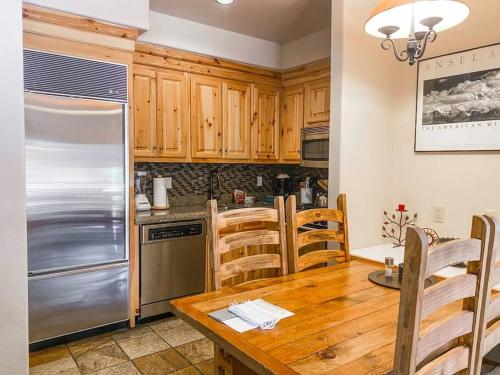 a kitchen with a wooden table and a stainless steel refrigerator at 2 BR Condominium - Luxury Skiin and out (rare to find) in Telluride