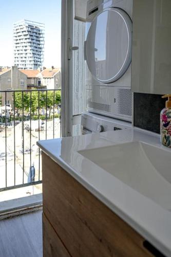 une cuisine avec un comptoir blanc et une fenêtre dans l'établissement F4 - La Maison de M Goéland - 4e etage, au Havre