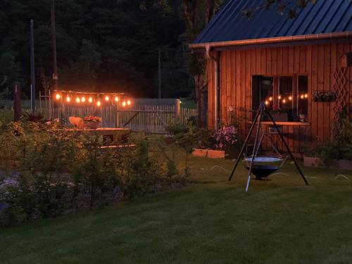 a backyard at night with a house with lights at Waldblick - Holiday home with wellness in Ouren in Burg-Reuland