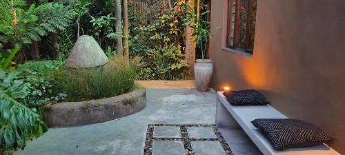 a patio with a bench and a room with plants at Dar Amane Guest House in Graskop