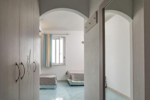 a bedroom with a bed and a hallway with an open door at Hotel Corallaro in Santa Teresa Gallura