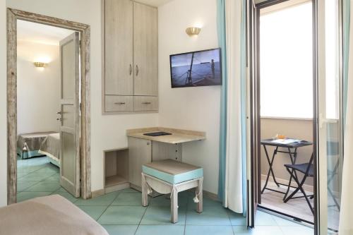 a room with a desk and a chair and a mirror at Hotel Corallaro in Santa Teresa Gallura