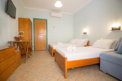 a bedroom with two beds and a blue couch at Sofia and Soul Studios in Kalamitsi