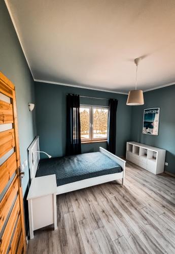 a bedroom with a bed and a window at Siedlisko Błotnia in Mierzeszyn