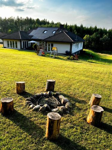 a group of tree stumps in front of a house at Siedlisko Błotnia in Mierzeszyn