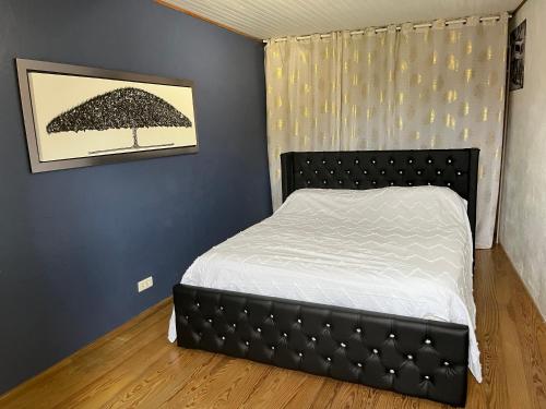 une chambre avec un lit dans une pièce aux murs bleus dans l'établissement Maison de ville au cœur de la Provence, à Sérignan-du-Comtat